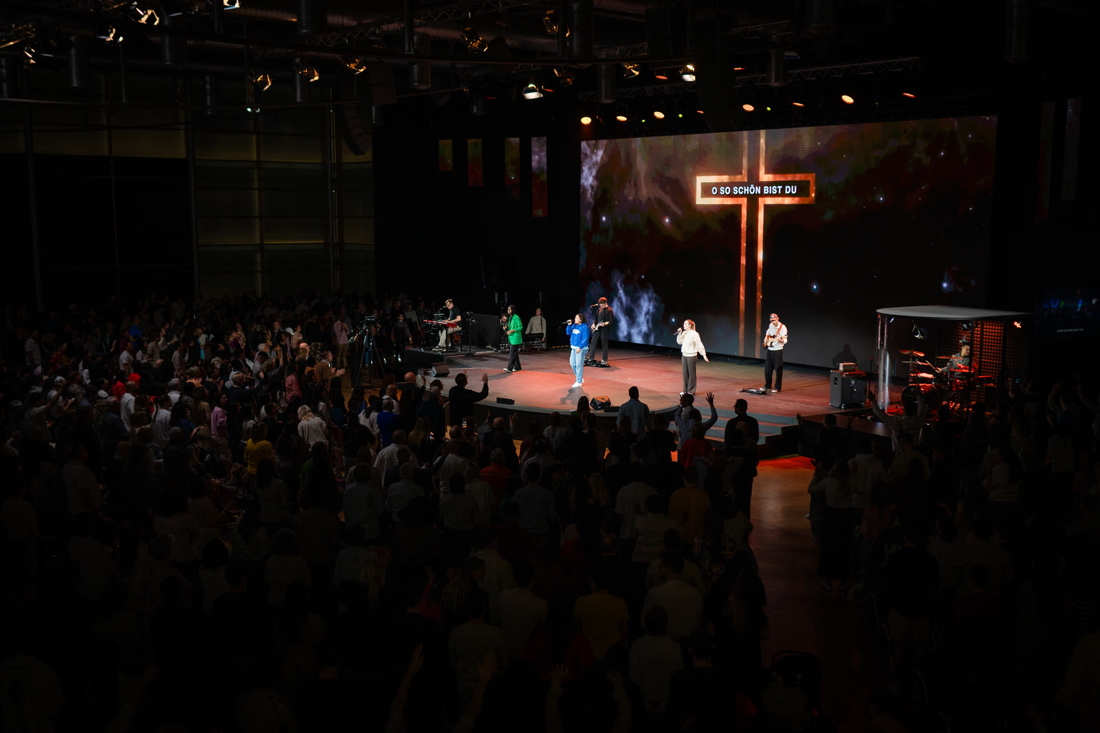 Gospel Forum Stuttgart main hall during a worship service with warm red content on the ArtePixel LED wall
